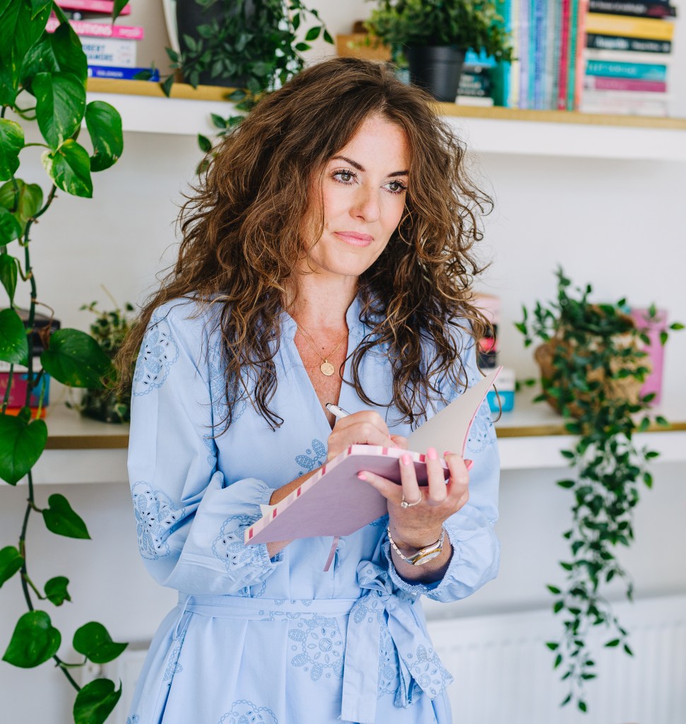Employment lawyer, Lousha, wearing blue dress holding notepad